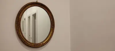 a mirror with a wooden frame on a wall at Casa Ponte della Musica in Rome