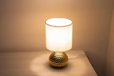 a gold lamp with a white shade on a table at Carpegna Sweet House - A few stops from the city centre in Rome
