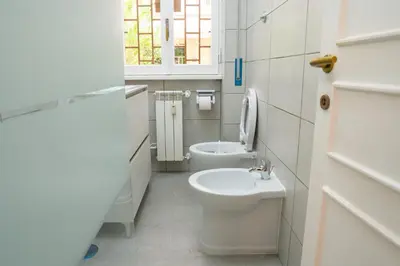 a white bathroom with a toilet and a sink at Carpegna Sweet House - A few stops from the city centre in Rome