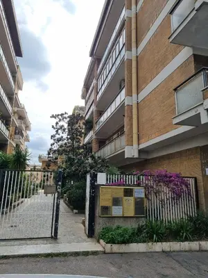 a fence in front of a building with purple flowers at Carpegna Sweet House - A few stops from the city centre in Rome