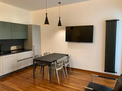 a kitchen and dining room with a table and chairs at Nox Romana Apartments - Vatican - Modern Apt with Cozy Balcony in Rome