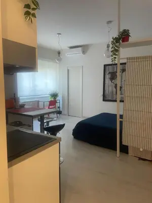 a room with a bed and a table and a kitchen at Chez Margot in Rome