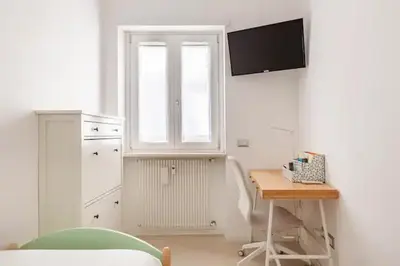 a white room with a desk and a window and a table at Vatican Flat in Rome