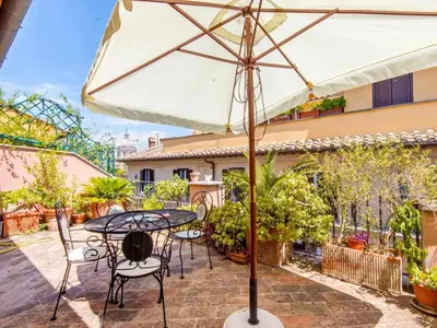 a patio with a table and chairs in front of a building at Apartment Charming Terrace by Interhome in Rome