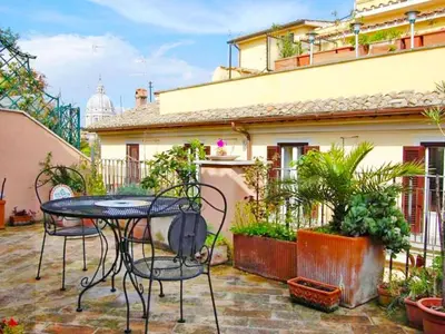 a patio with a table and chairs and an umbrella at Apartment Charming Terrace by Interhome in Rome