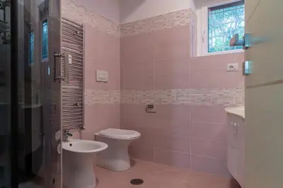 a pink bathroom with a toilet and a sink at DiTullio18 - Cipro Balduina in Rome