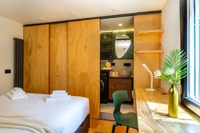 a bedroom with a bed and a green chair at iFlat Campo de' Fiori modern apartment in Rome