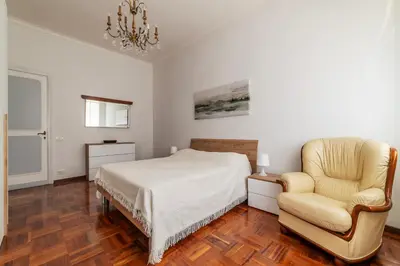 a bedroom with a bed and a chair at GuestHost - Villa Pamphili & Vaticano Cozy Apartment in Rome