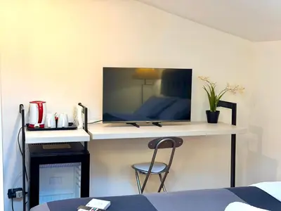 a room with a desk with a tv on a wall at Attic Garden in Rome