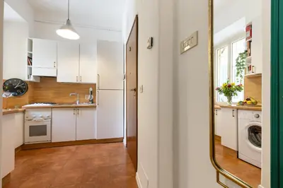 a kitchen with white cabinets and a mirror at Rome As You Feel - Cozy Open Space Near the Vatican in Rome