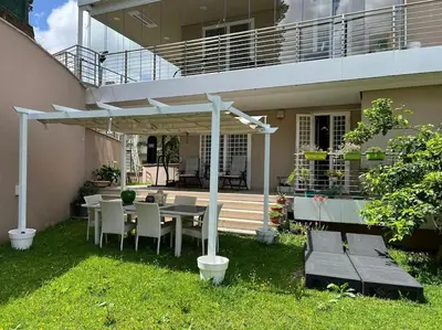 a patio with a table and chairs under a pergola at Enchanting Garden Retreat in Rome