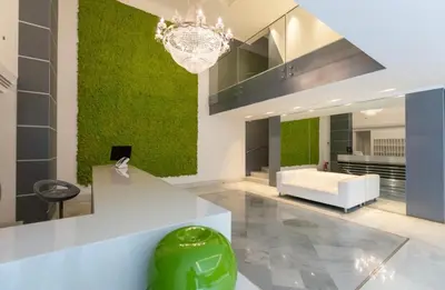 a living room with a green accent wall at Enchanting Garden Retreat in Rome