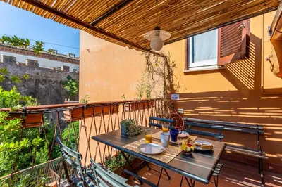 a patio with a table and chairs on a balcony at iFlat Peaceful apt with terrace next to Vatican in Rome