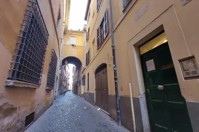an empty alley with a green door and buildings at Cappellari37 in Rome