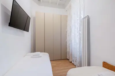 a bedroom with a bed and a tv on a wall at Rufina's Home in Rome