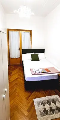 a bedroom with a bed and a wooden floor at VATICAN ERA Guest House in Rome