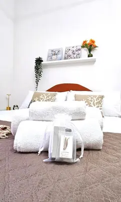 two beds in a bedroom with white sheets and a purse at VATICAN ERA Guest House in Rome