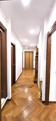 an empty hallway with white walls and wooden floors at VATICAN ERA Guest House in Rome