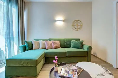 a living room with a green couch and a table at Vatican Pop House in Rome
