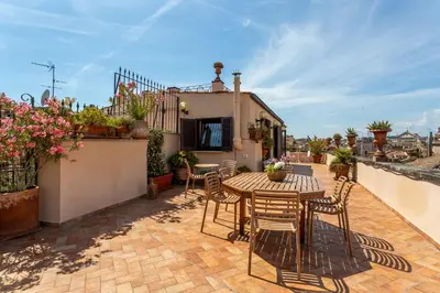 a patio with a table and chairs on a balcony at iFlat Campo de' Fiori Panoramic Penthouse in Rome