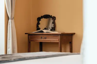 a dressing table with a mirror and a book on it at NAMAN HOTELLERIE - Monti in Rome