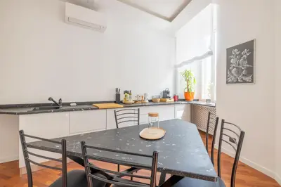a kitchen with a black table and chairs in a room at Cavour 211 - B&D Apartments in Rome