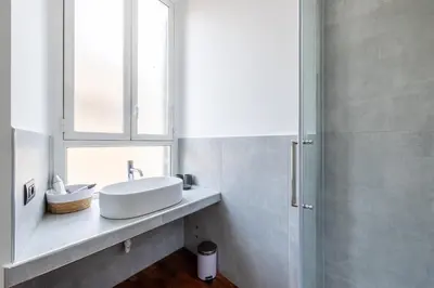 a white bathroom with a sink and a window at Cavour 211 - B&D Apartments in Rome