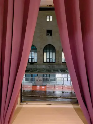 a view of a train station through a red curtain at Overseas Guesthouse in Rome