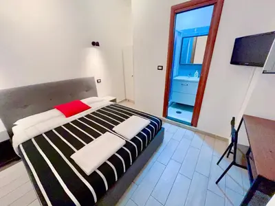 a bedroom with a large bed and a television at Overseas Guesthouse in Rome