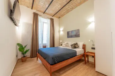 a small bedroom with a bed and a window at Luxury Vatican Rooms - next to the Vatican Museum in Rome