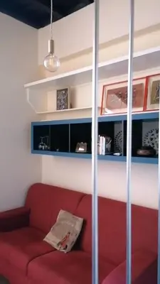 a living room with a red couch and shelves at Casa Lella al Borgo Pio, a pochi passi da San Pietro in Rome
