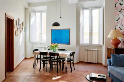 a living room with a table and chairs at TrastevereHome - Elegant Home Near Navona Square in Rome