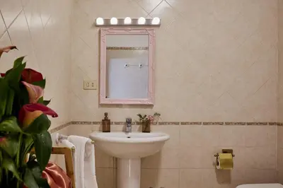 a bathroom with a sink and a mirror at TrastevereHome - Elegant Home Near Navona Square in Rome