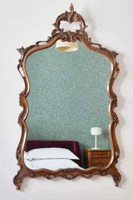 a mirror on a wall with a bed in a room at TrastevereHome - Elegant Home Near Navona Square in Rome