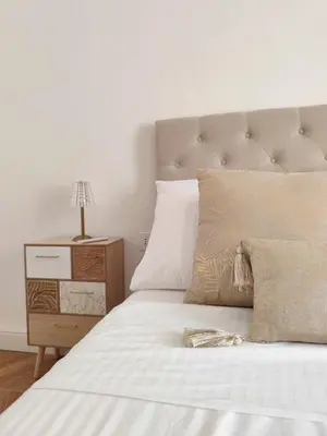 a bedroom with a white bed and a night stand at Vatican Eco Suite in Rome