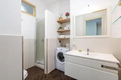 a white bathroom with a washing machine and a sink at 5 Minutes to St Peter - Luxury Stay in Rome