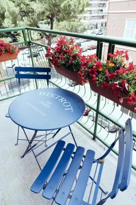 a blue table and chairs on a balcony with flowers at Domus Clelia in Rome