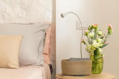a vase of flowers on a table next to a bed at Al Centro di Roma - Vaticano in Rome