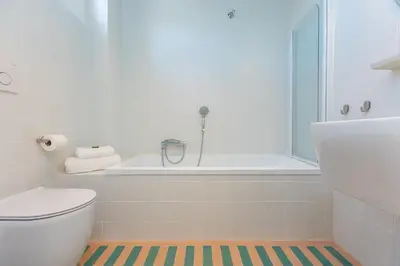 a bathroom with a tub and a toilet and a sink at Amazing Penthouse Vaticano in Rome