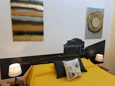 a bedroom with a yellow bed with two lamps at Re di Roma nice rooms in Rome