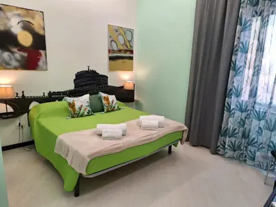 a bedroom with a green bed with towels on it at Re di Roma nice rooms in Rome