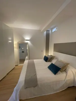 a bedroom with a large white bed with blue pillows at La Casetta di Ponte Milvio con parcheggio in Rome