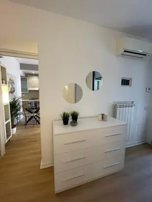 a living room with a white dresser and mirror at La Casetta di Ponte Milvio con parcheggio in Rome