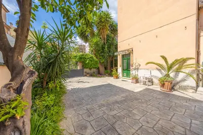 a courtyard with palm trees and a building at Casa Piazza Lodi in Rome