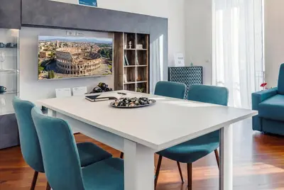 a dining room with a white table and blue chairs at Saint John Loft in Rome