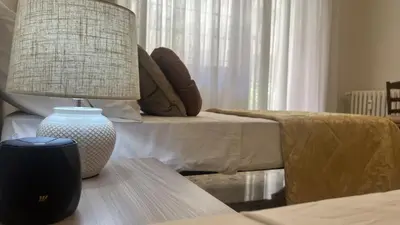 a lamp sitting on a table next to a bed at Luxury apartment San Giovanni in Rome