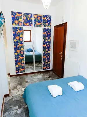 a bedroom with a blue bed and a mirror at Betania Loft in Rome