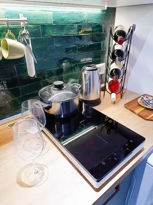 a stove with pots and pans on a counter with wine glasses at Betania Loft in Rome