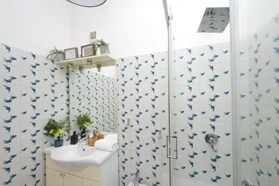 a bathroom with a shower with blue butterflies on the wall at Testaccio - Pretty Apartment in Rome
