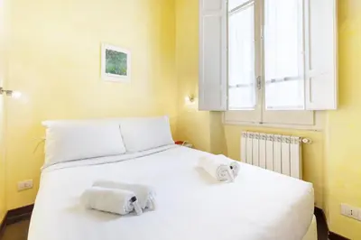 a bedroom with a white bed with towels on it at Hostly-Urban Oasis Turati-Few Steps from Colosseum in Rome